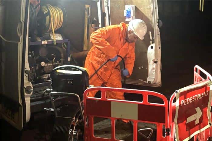 Drainage engineer unblocking a drain a night