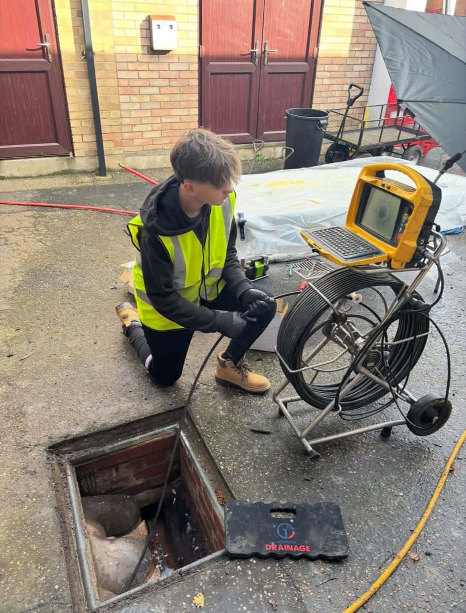 Drainage engineer inspecting an external drain after completing a no dig patch liner repair on a damaged pipe
